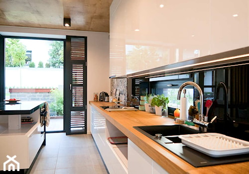 Współczesne wnętrza domu jednorodzinnego - Średnia otwarta z salonem biała czarna kuchnia jednorzędowa z wyspą lub półwyspem z oknem, styl nowoczesny - zdjęcie od Michał Hoffmann projektant wnętrz