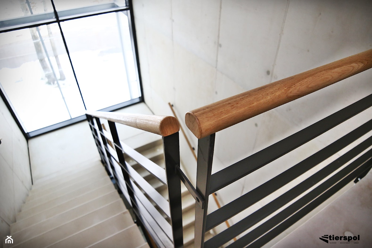 Balustrady z drewnianym pochwytem na klatce schodowej - zdjęcie od Tierspol producent schodów szklanych i całoszklanych - Homebook