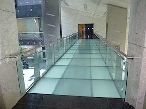 Schody w atrium biurowca Focus w Warszawieoraz szklana kładka nad wejściem głównym - zdjęcie od Tierspol producent schodów szklanych i całoszklanych