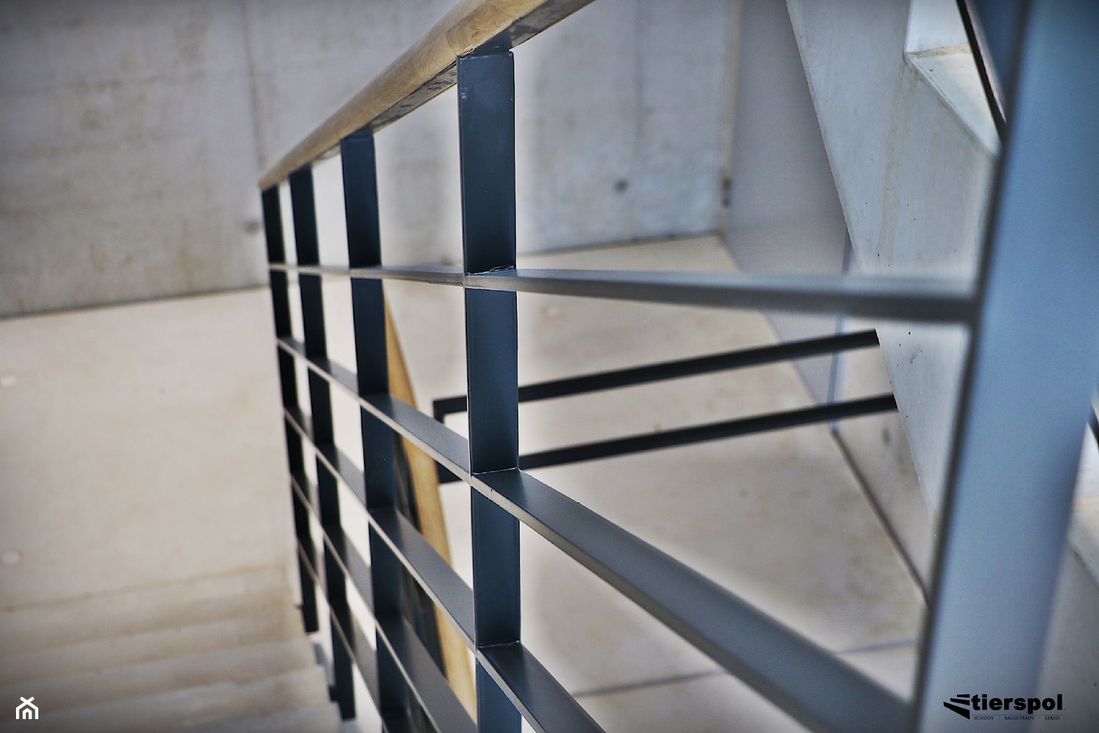 Balustrady z drewnianym pochwytem na klatce schodowej - zdjęcie od Tierspol producent schodów szklanych i całoszklanych - Homebook