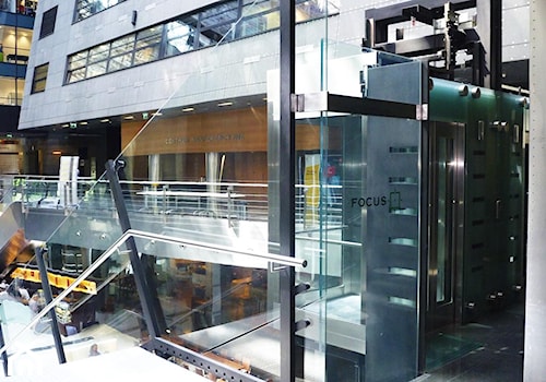 Schody w atrium biurowca Focus w Warszawieoraz szklana kładka nad wejściem głównym - zdjęcie od Tierspol producent schodów szklanych i całoszklanych