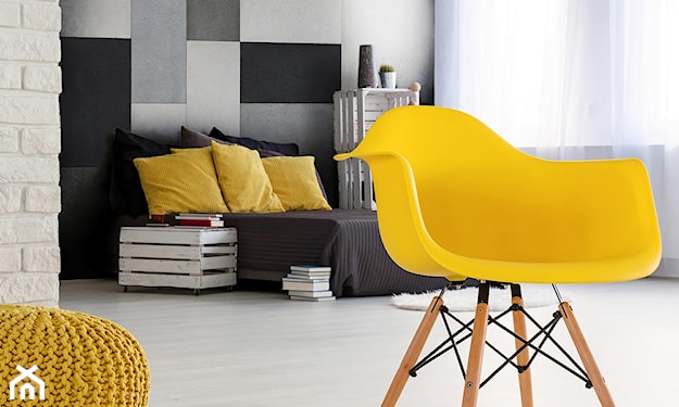 betonowe płytki ścienne, żółty fotel, żółte poduszki, żółta pufa