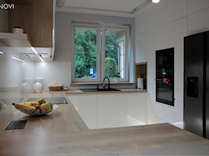 Biała kuchnia z drewnianym blatem - zdjęcie od NOVI projektowanie