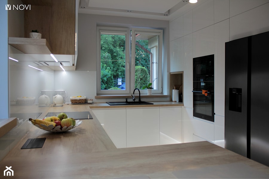 Biała kuchnia z drewnianym blatem - zdjęcie od NOVI projektowanie