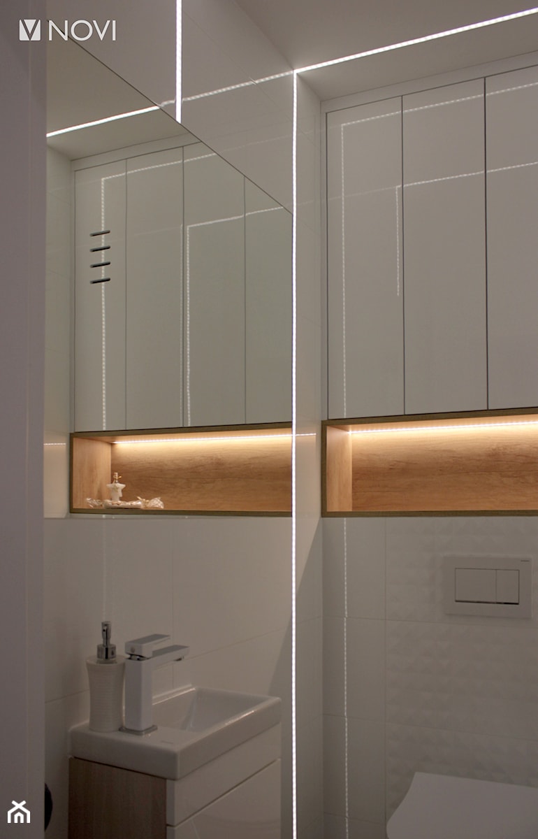 Biała toaleta z taśmami LED w ścianie i suficie - zdjęcie od NOVI projektowanie