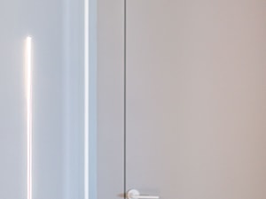 Kinkiet Icone Spillo minimalistyczny wbudowany w ścianę, obok drzwi z ościeżnicą ukrytą - zdjęcie od Pracownia Projektowania Wnętrz Małgorzata Czapla