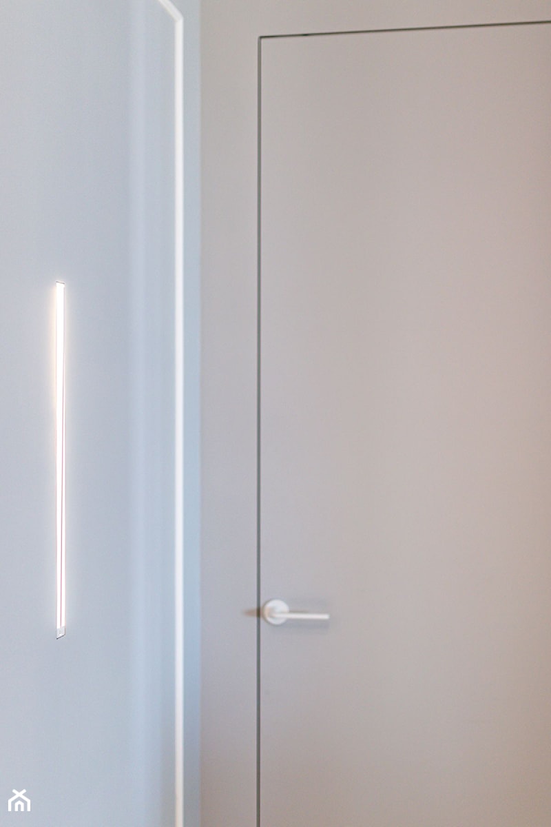 Drzwi ukryte i minimalistyczny kinkiet Icone Spillo - zdjęcie od Pracownia Projektowania Wnętrz Małgorzata Czapla