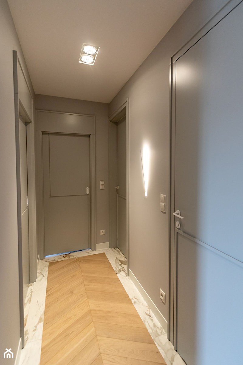 minimalistyczny hol z drzwiami indywidalnego projektu i kinkietem Icone Spillo - zdjęcie od Pracownia Projektowania Wnętrz Małgorzata Czapla