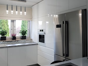 kuchnie lakierowane nowoczesne - Średnia otwarta z salonem biała z zabudowaną lodówką z lodówką wolnostojącą z nablatowym zlewozmywakiem kuchnia w kształcie litery l z oknem - zdjęcie od Projekt-Kuchnie