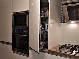 kuchnie lakierowane nowoczesne - Mała otwarta biała z zabudowaną lodówką kuchnia jednorzędowa, styl nowoczesny - zdjęcie od Projekt-Kuchnie