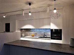 kuchnie lakierowane nowoczesne - Duża otwarta z kamiennym blatem szara z zabudowaną lodówką z nablatowym zlewozmywakiem kuchnia dwurzędowa z marmurem nad blatem kuchennym - zdjęcie od Projekt-Kuchnie