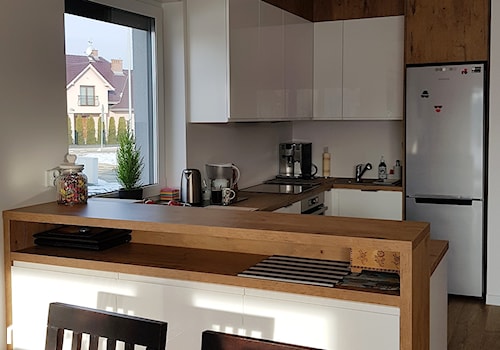 kuchnie lakierowane nowoczesne - Średnia otwarta biała z zabudowaną lodówką z podblatowym zlewozmywakiem kuchnia w kształcie litery u z oknem - zdjęcie od Projekt-Kuchnie