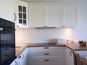 KUCHNIA - Średnia otwarta biała z zabudowaną lodówką z podblatowym zlewozmywakiem kuchnia w kształcie litery u - zdjęcie od Projekt-Kuchnie