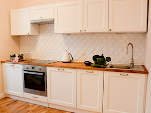 Mieszkanie 50 m2 w starej kamienicy - Mała otwarta z salonem beżowa biała z podblatowym zlewozmywakiem kuchnia jednorzędowa, styl tradycyjny - zdjęcie od Decolatorium