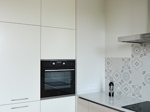 Mieszkanie w Forcie - Mała zamknięta z kamiennym blatem biała szara z zabudowaną lodówką kuchnia w kształcie litery l, styl nowoczesny - zdjęcie od GUST MEBLE