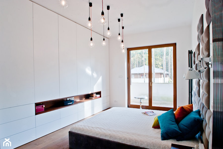 W starych sosnach - Średnia biała sypialnia z balkonem / tarasem - zdjęcie od We-ska design.