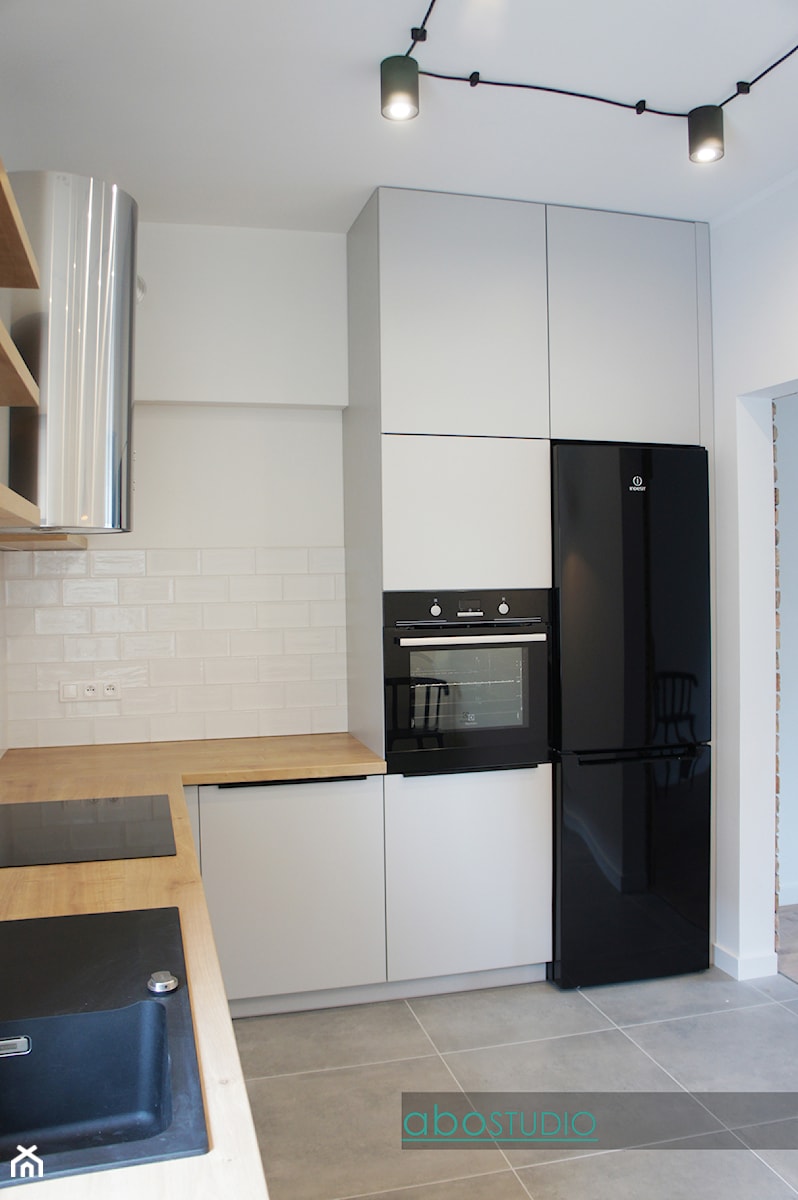 Mieszkanie na wynajem - Płock - Mała zamknięta biała z zabudowaną lodówką z nablatowym zlewozmywakiem kuchnia w kształcie litery l, styl industrialny - zdjęcie od abostudio
