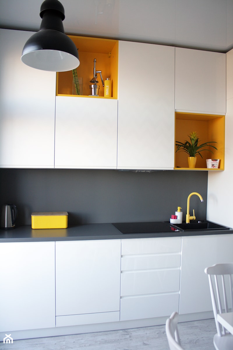 Mieszkanie z żółtymi akcentami - Mała zamknięta z kamiennym blatem biała z zabudowaną lodówką z nablatowym zlewozmywakiem kuchnia jednorzędowa, styl industrialny - zdjęcie od studio BOMBE