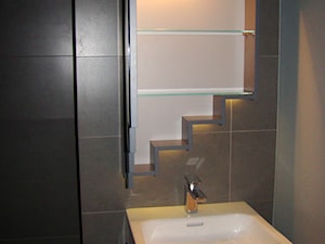 Zbliżenie na lustro z widokiem na szklane półki w środku - Realizacja łazienki pod schodami - zdjęcie od Tucano Polska