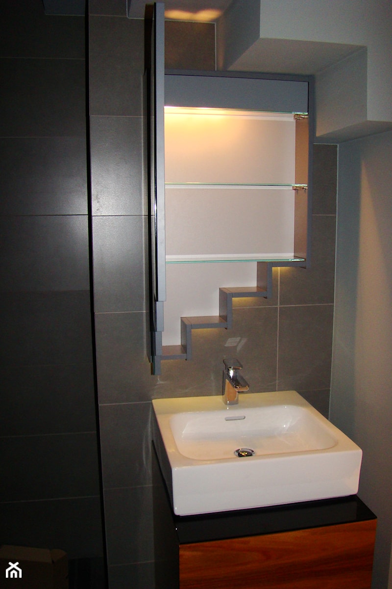 Zbliżenie na lustro z widokiem na szklane półki w środku - Realizacja łazienki pod schodami - zdjęcie od Tucano Polska