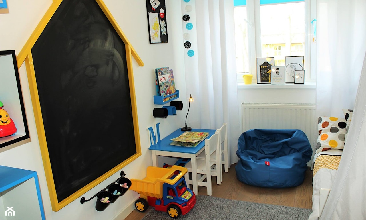 tablica w pokoju dziecięcym, niebieskie siedzisko, białe zasłony, niebieskie kule ozdobne, poduszka w kropki