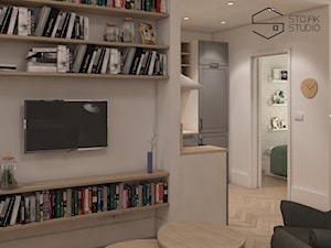 Niewielkie mieszkania na wynajem - Mały szary salon z bibiloteczką, styl skandynawski - zdjęcie od Stojak Studio