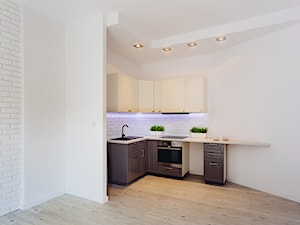 Kuchnia - Mała otwarta z salonem biała z zabudowaną lodówką kuchnia w kształcie litery l, styl minimalistyczny - zdjęcie od Michał Marciniak