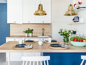 Apartament w Rewalu - Mała otwarta biała niebieska z zabudowaną lodówką z nablatowym zlewozmywakiem kuchnia dwurzędowa - zdjęcie od STRAŻYŃSKI STUDIO