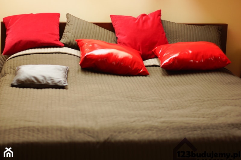 Łóżko brązowa narzuta czerwone poduszki - zdjęcie od 123budujemy.pl