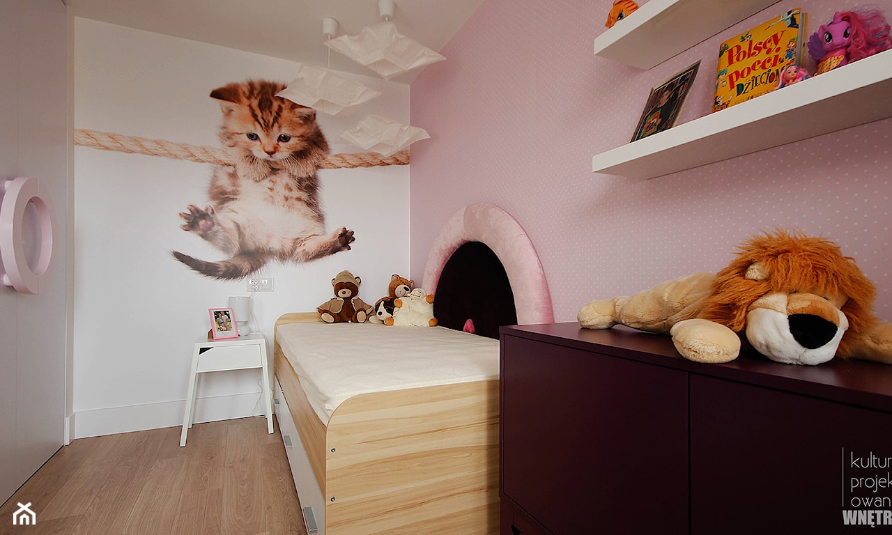 fototapeta z małym kotkiem w pokoju dziewczynki, różowa tapeta w białe kropki, drewniana podłoga