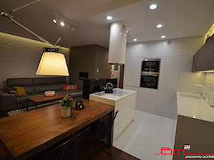 projekt mieszkania 65m2 - Średnia z salonem biała z zabudowaną lodówką z podblatowym zlewozmywakiem kuchnia w kształcie litery l z wyspą lub półwyspem, styl nowoczesny - zdjęcie od bm2 brzostek maciej