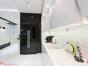 czarno- biały apartament 125m2 - Średnia otwarta z salonem biała z podblatowym zlewozmywakiem kuchnia w kształcie litery u z kompozytem na ścianie nad blatem kuchennym, styl minimalistyczny - zdjęcie od bm2 brzostek maciej