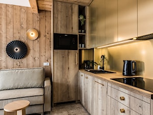 Mieszkanie weekendowe Białka Tatrzańska - Mała otwarta z salonem beżowa z zabudowaną lodówką z kuchenką mikrofalową z nablatowym zlewozmywakiem kuchnia ze złotymi frontami w kształcie litery l, styl nowoczesny - zdjęcie od Krecha Studio