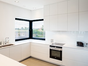 DOM SIADŁO - Średnia otwarta biała z zabudowaną lodówką kuchnia w kształcie litery u z oknem, styl nowoczesny - zdjęcie od ANNA THUROW Architektura i wnętrza