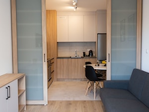 Salon z kuchnią oddzieloną przesuwnymi drzwiami - zdjęcie od OHHOME - projekty, remonty, meble