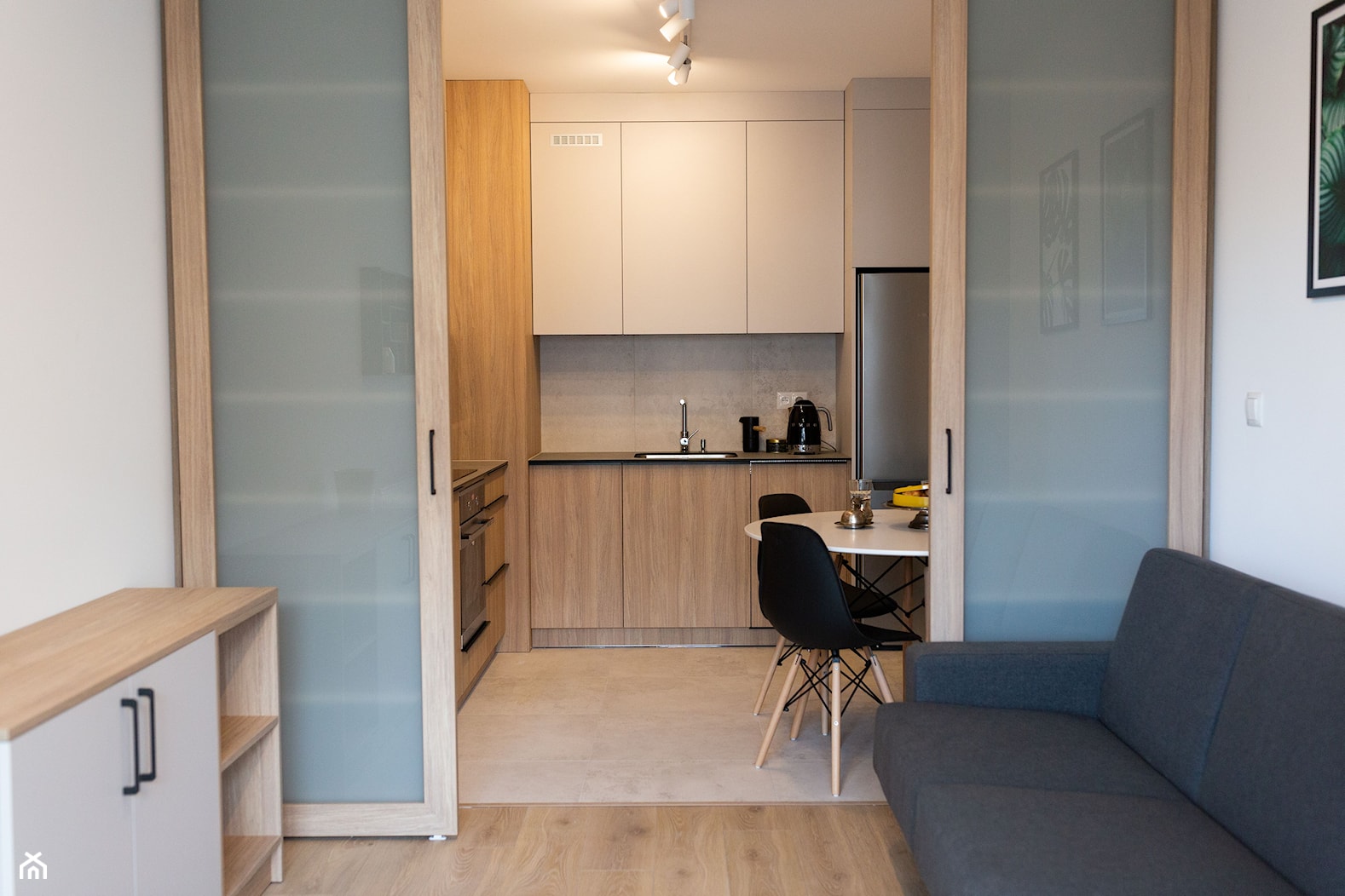Salon z kuchnią oddzieloną przesuwnymi drzwiami - zdjęcie od OHHOME - projekty, remonty, meble - Homebook