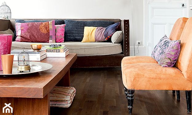 ciemna drewniana podłoga w salonie z pomarańczowym fotelem