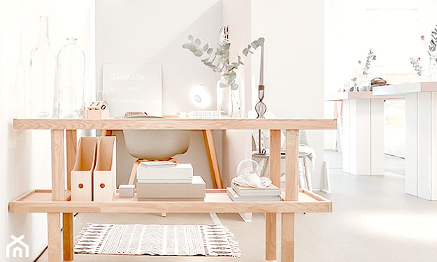 biurko z jasnego drewna, białe krzesło, białe ściany