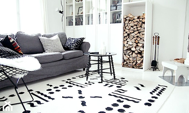 szara sofa, czarny okrągły stolik, biały dywan z czarnym wzorem