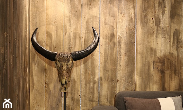 drewniana ściana, brązowa sofa, miedziana lampa wisząca