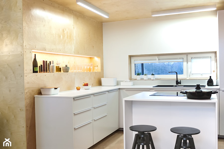 Otwarta na salon kuchnia z wyspą do gotowania, którą wyposażono w płytę indukcyjną. - zdjęcie od SZARA/studio