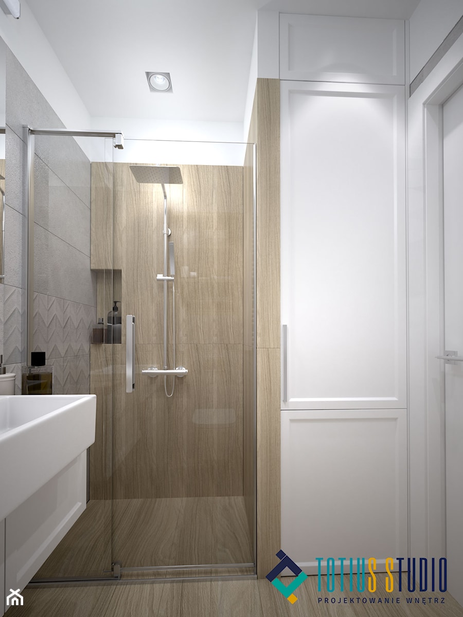 Płytki pod prysznicem i wysoka zabudowa meblowa łazienki - zdjęcie od Totius Studio