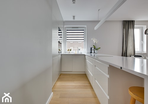 Mieszkanie wg autorstwa studia KAST DESIGN z Paryża - Średnia otwarta z salonem z kamiennym blatem biała z zabudowaną lodówką kuchnia w kształcie litery u z oknem, styl minimalistyczny - zdjęcie od Radosław Sobik Fotografia