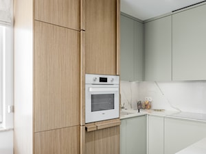 Mieszkanie w Gdańsku · Realizacja - Mała otwarta z kamiennym blatem szara z zabudowaną lodówką z nablatowym zlewozmywakiem kuchnia w kształcie litery u z oknem z marmurem nad blatem kuchennym, styl nowoczesny - zdjęcie od WOJSZ studio