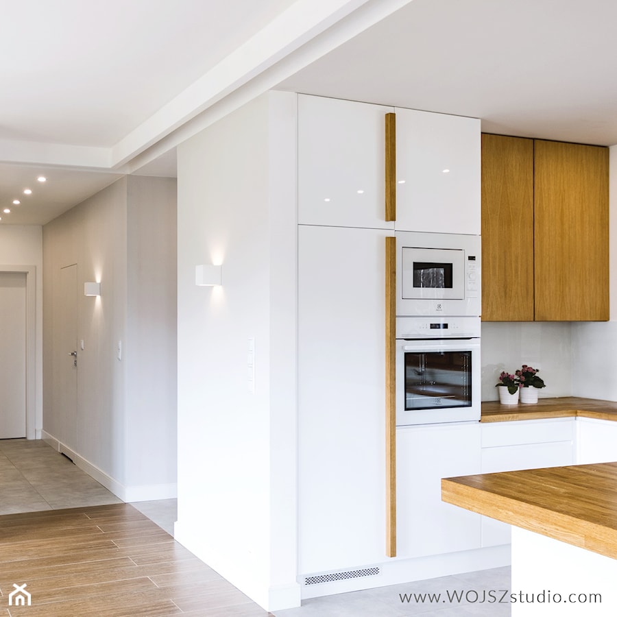 Dom w Rąbie · Realizacja - Średnia otwarta z salonem biała z zabudowaną lodówką kuchnia w kształcie litery g, styl nowoczesny - zdjęcie od WOJSZ studio
