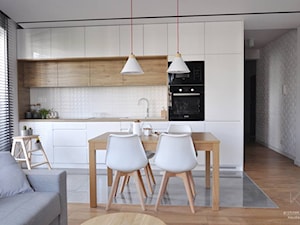 Mieszkanie Kraków,50m2. Realizacja - Mała biała szara jadalnia w salonie w kuchni, styl nowoczesny - zdjęcie od STUDIO PNIAK