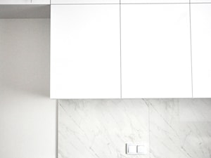 Lokal mieszkalny przy ul. Długiej w Krakowie - Z kamiennym blatem biała kuchnia jednorzędowa z marmurem nad blatem kuchennym, styl nowoczesny - zdjęcie od PAAS Pracownia Projektowa