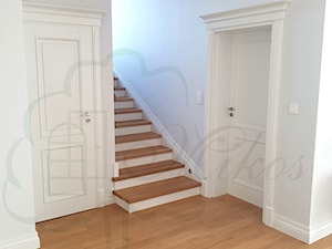 Stylowe schody drewniane w kolorze naturalnym i białymi podstopniami oraz z tralkami toczonymi oraz zdobną obróbką - zdjęcie od STOLARKA MIKOS