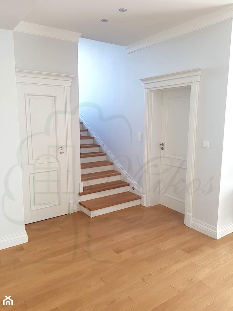 Stylowe schody drewniane w kolorze naturalnym i białymi podstopniami oraz z tralkami toczonymi oraz zdobną obróbką - zdjęcie od STOLARKA MIKOS - Homebook