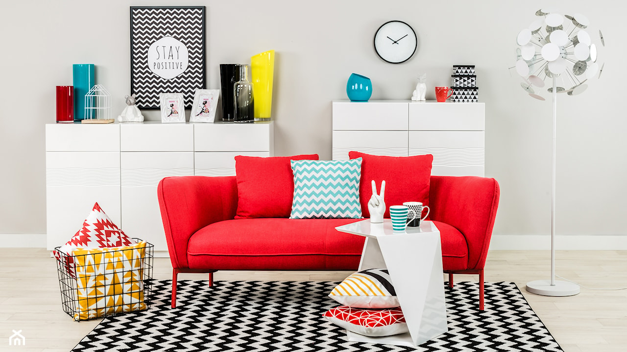 czerwona sofa, dodatki w intensywnych kolorach, czarno-biały dywan